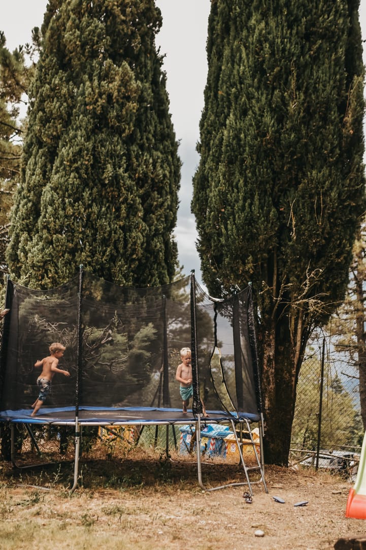 Trampoline tussen de cipressen