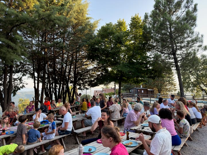 Een lange tafel vol campinggasten